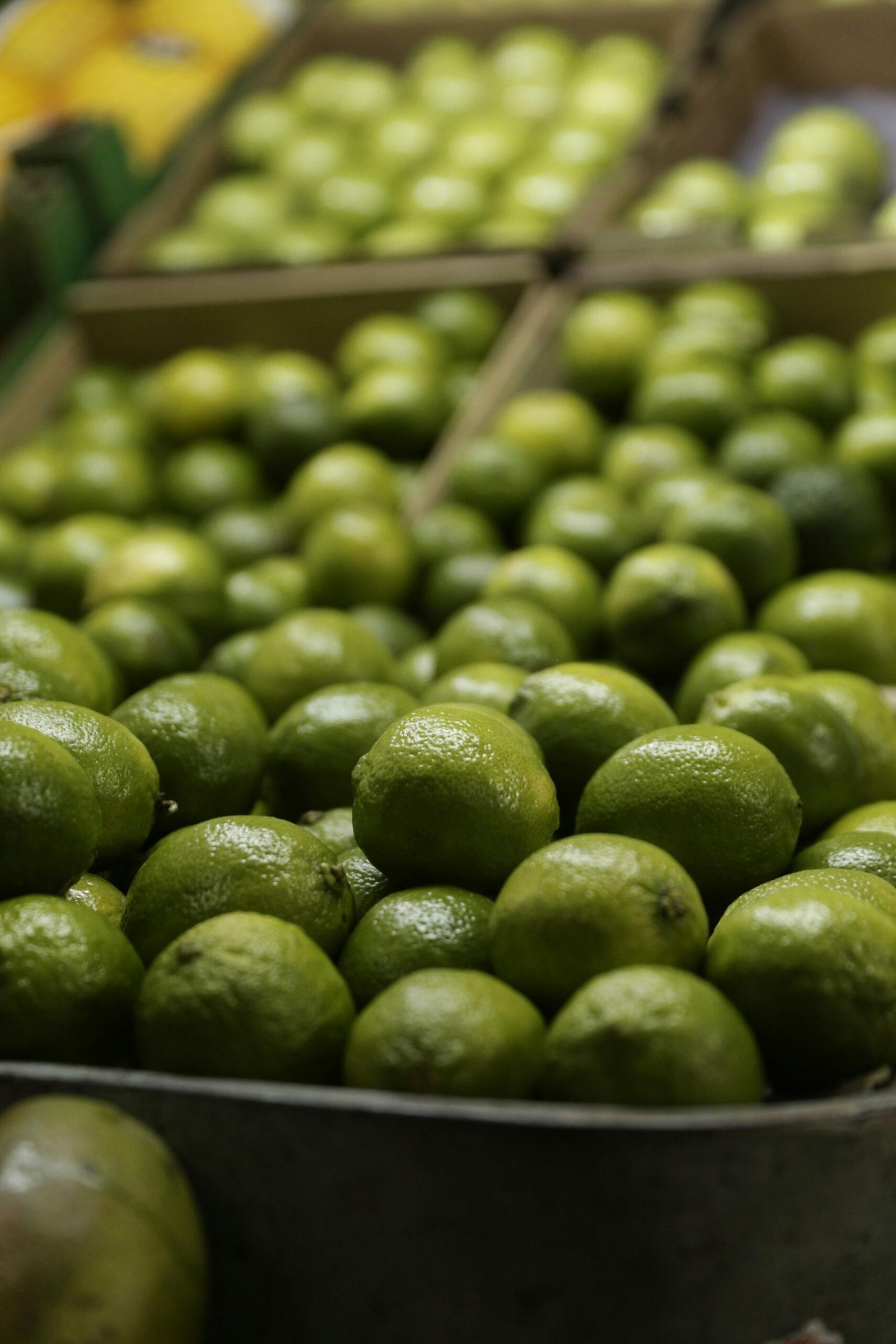 Close-up of fresh limes in a market, perfect for cooking and cocktails.